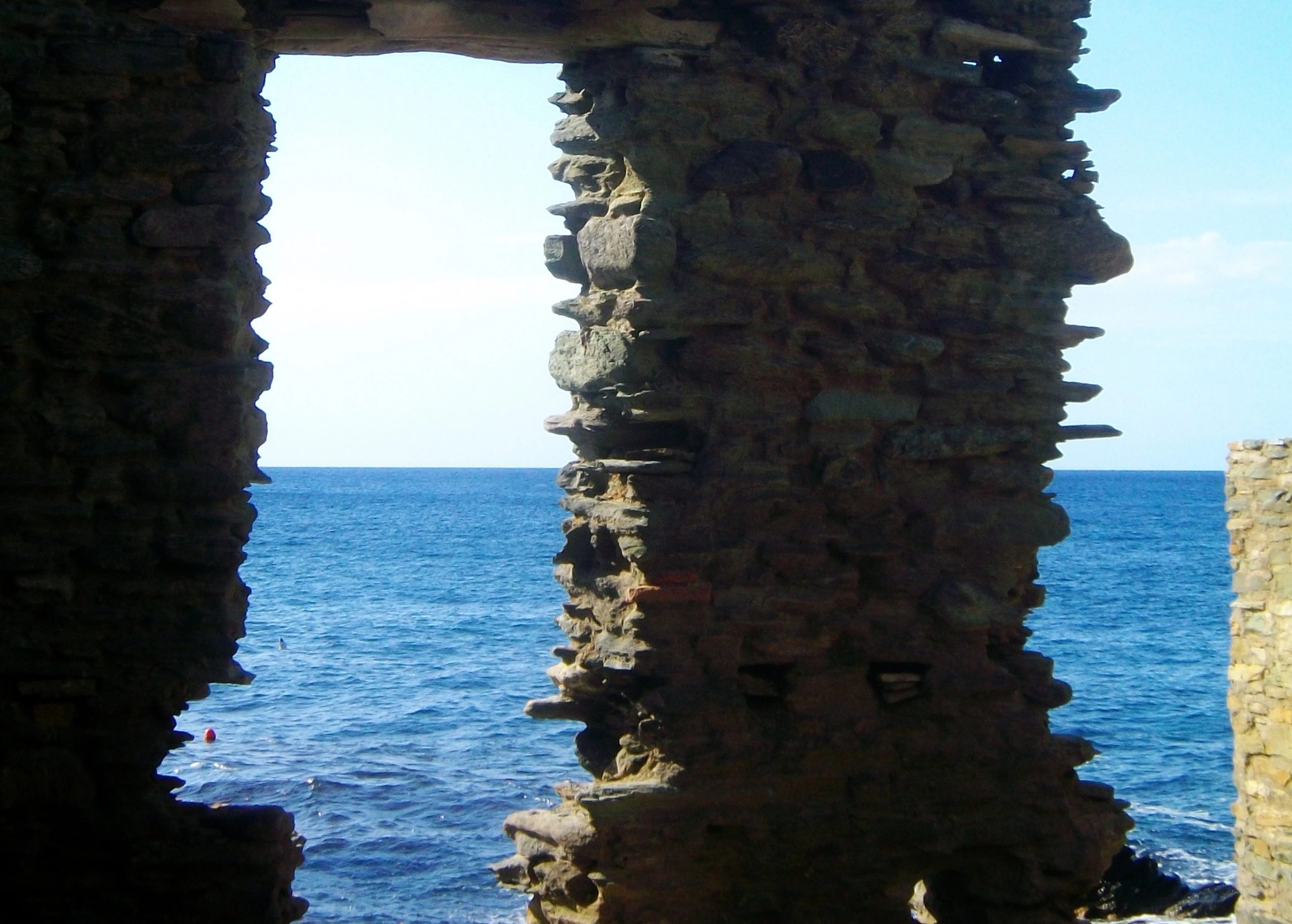 paysage vue sur la mer à travers un édifice en pierre